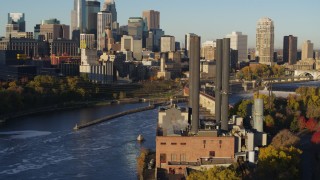 DX0001_002324 - 5.7K aerial stock footage of orbit riverfront power plant at sunrise, with view of Downtown Minneapolis, Minnesota
