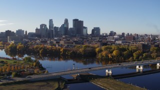 DX0001_002337 - 5.7K aerial stock footage reverse view of city's skyline during ascent from bridge and river, Downtown Minneapolis, Minnesota