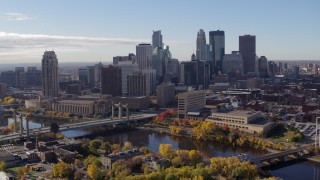 DX0001_002356 - 5.7K aerial stock footage of flying by bridges spanning the river and the city's skyline, Downtown Minneapolis, Minnesota