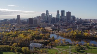 DX0001_002363 - 5.7K aerial stock footage flying by the city's skyline across the river, seen from a park, Downtown Minneapolis, Minnesota
