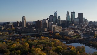 DX0001_002501 - 5.7K aerial stock footage descend by trees with view of city skyline and Mississippi River, Downtown Minneapolis, Minnesota