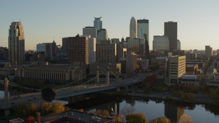 DX0001_002514 - 5.7K aerial stock footage reverse view of Hennepin Avenue Bridge and city skyline at sunset, Downtown Minneapolis, Minnesota