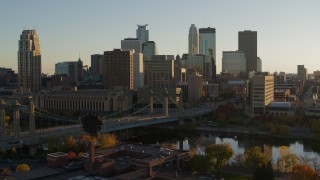 DX0001_002515 - 5.7K aerial stock footage flying by Hennepin Avenue Bridge and city skyline at sunset, Downtown Minneapolis, Minnesota