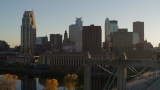 DX0001_002517 - 5.7K aerial stock footage ascend by Hennepin Avenue Bridge, USPS and apartment buildings at sunset, Downtown Minneapolis, Minnesota