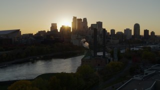 DX0001_002519 - 5.7K aerial stock footage of the city skyline across the river and a power plant at sunset, Downtown Minneapolis, Minnesota