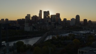 DX0001_002522 - 5.7K aerial stock footage of flying by the city skyline across the river at sunset, reveal power plant, Downtown Minneapolis, Minnesota