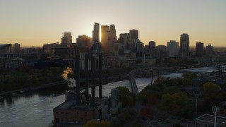 DX0001_002523 - 5.7K aerial stock footage of flying by power plant, with the city skyline across river at sunset, Downtown Minneapolis, Minnesota
