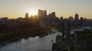 DX0001_002525 - 5.7K aerial stock footage of flying by the power plant and river at sunset, focus on skyline, Downtown Minneapolis, Minnesota
