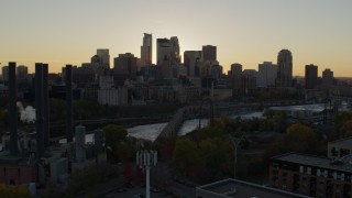 DX0001_002529 - 5.7K aerial stock footage view of city skyline while flying by bridge and river at sunset, reveal power plant, Downtown Minneapolis, Minnesota