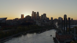 DX0001_002532 - 5.7K aerial stock footage of city skyline across the Mississippi River at sunset, reveal power plant, Downtown Minneapolis, Minnesota