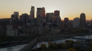 DX0001_002534 - 5.7K aerial stock footage of city skyline across the Mississippi River at sunset, reveal power plant, Downtown Minneapolis, Minnesota