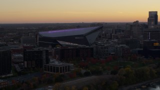 DX0001_002544 - 5.7K aerial stock footage of flying by US Bank Stadium at sunset, Downtown Minneapolis, Minnesota