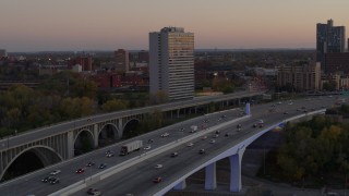 DX0001_002547 - 5.7K aerial stock footage of cars crossing a bridge near condo complex at sunset, Minneapolis, Minnesota