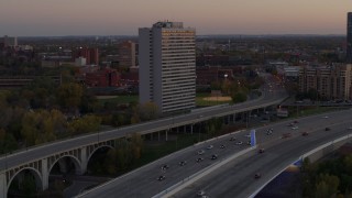DX0001_002549 - 5.7K aerial stock footage of reverse view of a condo complex beside a bridge at sunset, Minneapolis, Minnesota