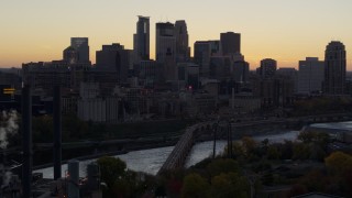 DX0001_002555 - 5.7K aerial stock footage of the city's skyline, bridge and the river at sunset, reveal power plant, Downtown Minneapolis, Minnesota