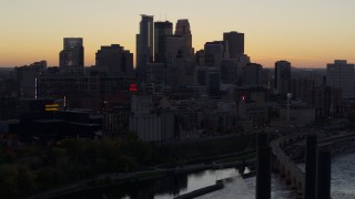 DX0001_002557 - 5.7K aerial stock footage of the city's skyline across the river at sunset, reveal a bridge, Downtown Minneapolis, Minnesota