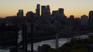 DX0001_002558 - 5.7K aerial stock footage of the city's skyline and river bridge at sunset, seen from power plant, Downtown Minneapolis, Minnesota