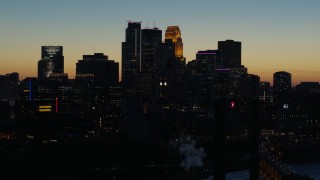 DX0001_002582 - 5.7K aerial stock footage descend by the city skyline lit for the night at twilight, Downtown Minneapolis, Minnesota