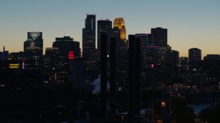 DX0001_002583 - 5.7K aerial stock footage flyby smoke stacks and the city skyline lit for the night at twilight, Downtown Minneapolis, Minnesota