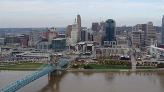 DX0001_002598 - 5.7K aerial stock footage of a reverse view of the city skyline and bridge by Ohio River, Downtown Cincinnati, Ohio