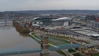 DX0001_002612 - 5.7K aerial stock footage orbit football stadium before flying away from bridge, Downtown Cincinnati, Ohio