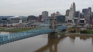 DX0001_002639 - 5.7K aerial stock footage fly away from the Roebling Bridge spanning Ohio River near the city skyline, Downtown Cincinnati, Ohio
