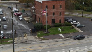DX0001_002716 - 5.7K aerial stock footage descend and fly away from a brick police station in Columbus, Ohio