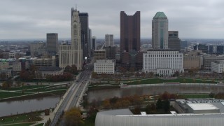 DX0001_002720 - 5.7K aerial stock footage of flying by Discovery Bridge and Scioto River by city skyline, Downtown Columbus, Ohio