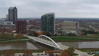 DX0001_002736 - 5.7K aerial stock footage reverse view of riverfront condo complex and office building by bridge and river, Downtown Columbus, Ohio