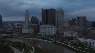DX0001_002743 - 5.7K aerial stock footage fly by and away from the city skyline by the Scioto River at sunset, Downtown Columbus, Ohio