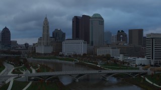 DX0001_002746 - 5.7K aerial stock footage approach the city skyline from bridges spanning the Scioto River at sunset, Downtown Columbus, Ohio