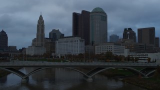 DX0001_002749 - 5.7K aerial stock footage ascend from bridge for view of the city skyline and the Scioto River at sunset, Downtown Columbus, Ohio
