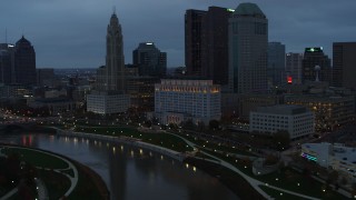 DX0001_002756 - 5.7K aerial stock footage of flying by Scioto River and city skyline at sunset, Downtown Columbus, Ohio