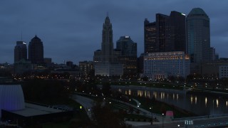 DX0001_002767 - 5.7K aerial stock footage ascend by the river with view of city skyline at twilight in Downtown Columbus, Ohio