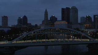 DX0001_002770 - 5.7K aerial stock footage flying by bridge with the city skyline in the background at twilight, Downtown Columbus, Ohio