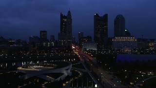 DX0001_002775 - 5.7K aerial stock footage of passing by the city skyline across the bridge and river at twilight, Downtown Columbus, Ohio