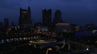 DX0001_002776 - 5.7K aerial stock footage of the city skyline across the bridge and river at twilight during descent, Downtown Columbus, Ohio
