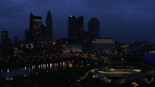 DX0001_002777 - 5.7K aerial stock footage of the city skyline across the bridge and river at twilight during ascent, Downtown Columbus, Ohio