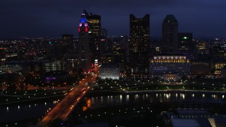 DX0001_002785 - 5.7K aerial stock footage of the city's skyline across a bridge and river at twilight, Downtown Columbus, Ohio