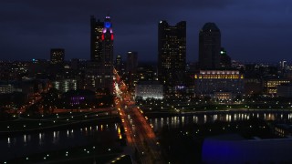 DX0001_002786 - 5.7K aerial stock footage of flying by the city's skyline across a bridge and river at twilight, Downtown Columbus, Ohio