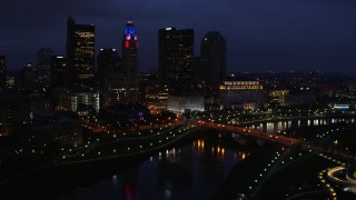 DX0001_002789 - 5.7K aerial stock footage of the city's skyline and a bridge spanning the river at twilight, Downtown Columbus, Ohio