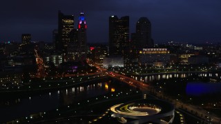 DX0001_002790 - 5.7K aerial stock footage of a bridge spanning the river and city skyline at twilight, Downtown Columbus, Ohio