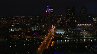 DX0001_002799 - 5.7K aerial stock footage of passing by the city skyline, and bridge spanning the river at night, Downtown Columbus, Ohio