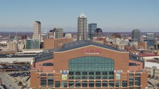 DX0001_002824 - 5.7K aerial stock footage of flying by the football stadium, ascend to reveal skyline in Downtown Indianapolis, Indiana
