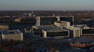 DX0001_002916 - 5.7K aerial stock footage of flying by a large hospital complex at sunset in Indianapolis, Indiana