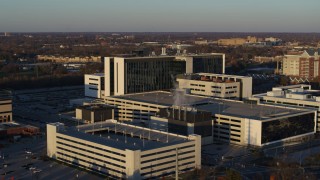 DX0001_002917 - 5.7K aerial stock footage of orbiting a large hospital complex at sunset in Indianapolis, Indiana