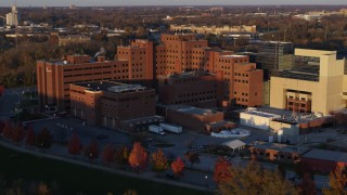 DX0001_002920 - 5.7K stock footage aerial video pass and fly away from a VA hospital complex at sunset in Indianapolis, Indiana