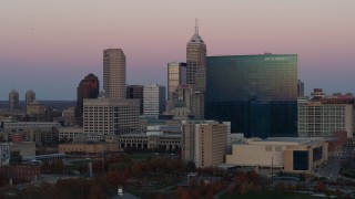 DX0001_002939 - 5.7K aerial stock footage of flying by hotel and the city's skyline at sunset, Downtown Indianapolis, Indiana
