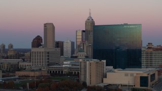 DX0001_002940 - 5.7K aerial stock footage of flying by hotel to reveal the city's skyline at sunset, Downtown Indianapolis, Indiana