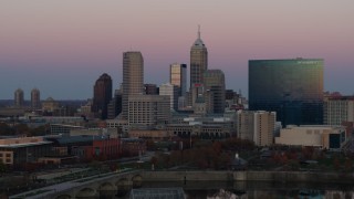 DX0001_002942 - 5.7K aerial stock footage of flying away from hotel and city's skyline at sunset, Downtown Indianapolis, Indiana